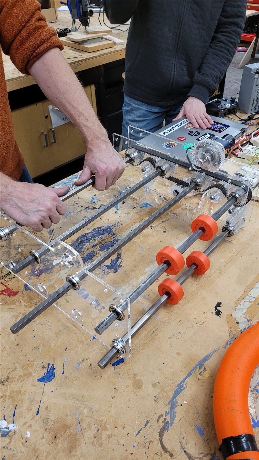 Team members assembling the intake with orange rollers
