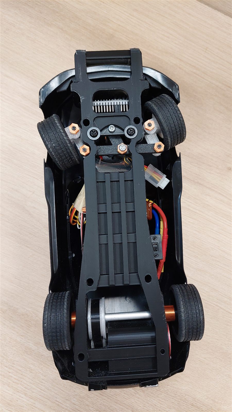 Underside of the RC car showing the 3D printed chassis and belt drive